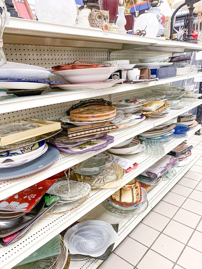 shelves in a thrift store displaying serving dishes for sale